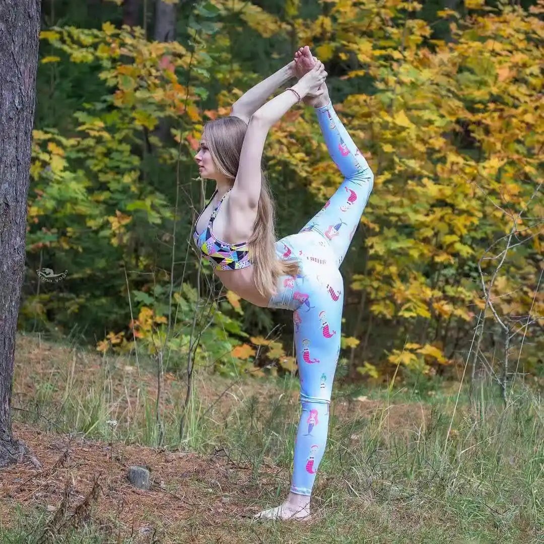 Woman practicing yoga outdoors wearing Beauty Fitness Yoga Pants with colorful design.