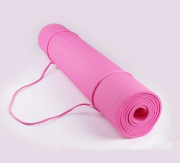 Pink non-slip yoga mat with strap, lightweight and durable, for enhanced stability during yoga practice.