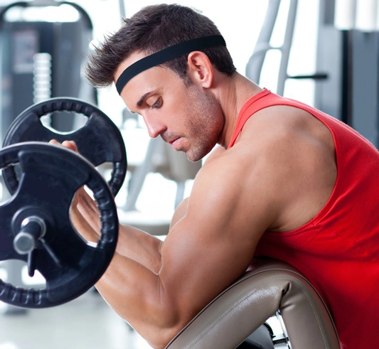 Man working out in gym wearing black fitness yoga hair band.