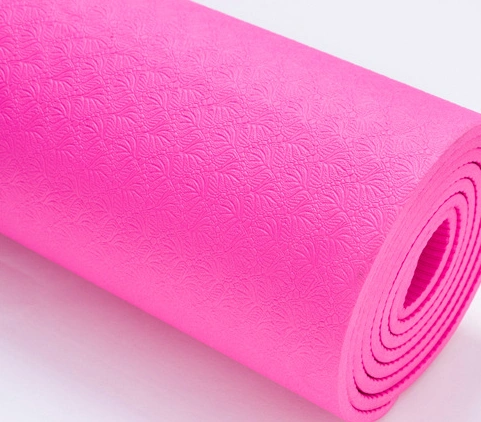 Pink non-slip yoga mat with textured surface for stability and cushioning.