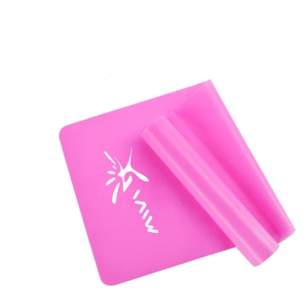 Pink yoga fitness resistance band rolled on a white surface.