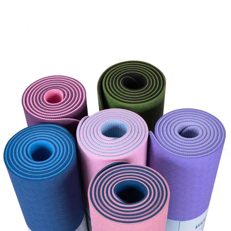 Two-color 6mm yoga mat with posture lines in various colors rolled and ready for fitness sessions.