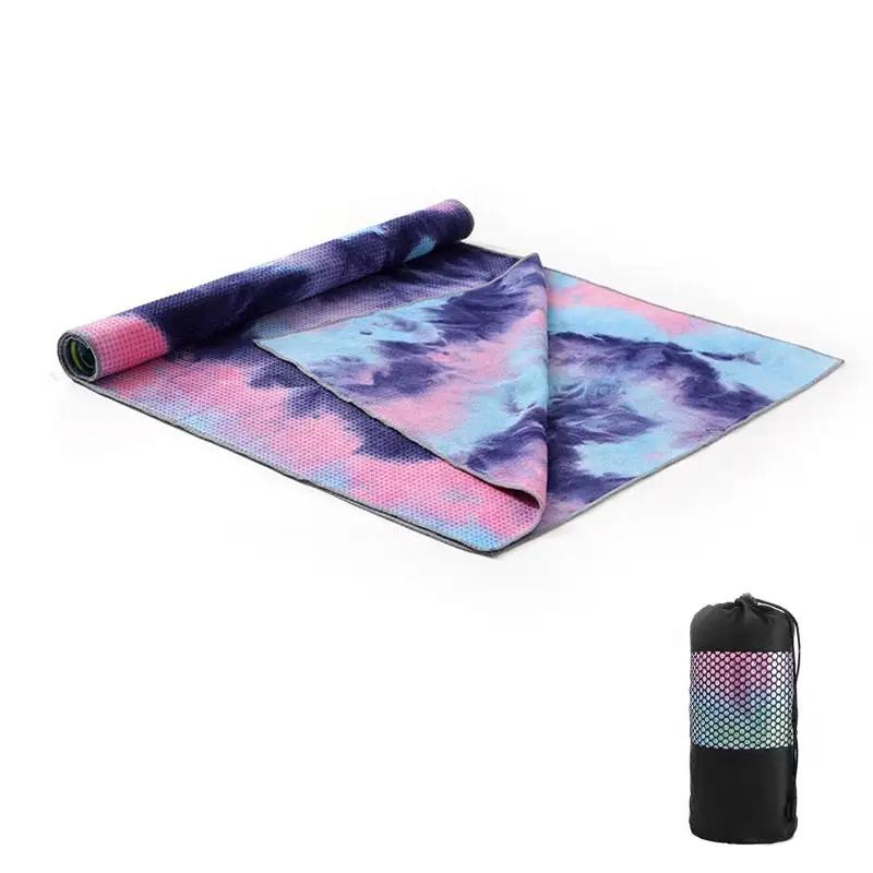 Tie-dye yoga blanket pad towel with vibrant colors, rolled with included net bag.