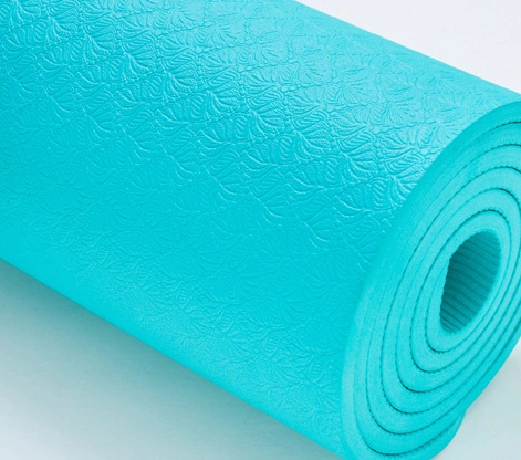 Turquoise non-slip yoga mat close-up with textured surface.