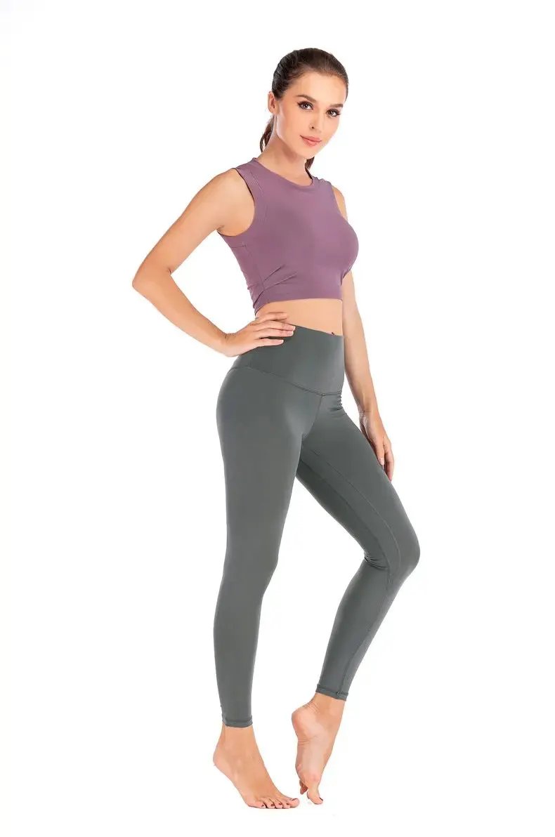 Female model wearing a lotus pink fitness sports yoga vest and gray leggings, ideal for sports and yoga activities.