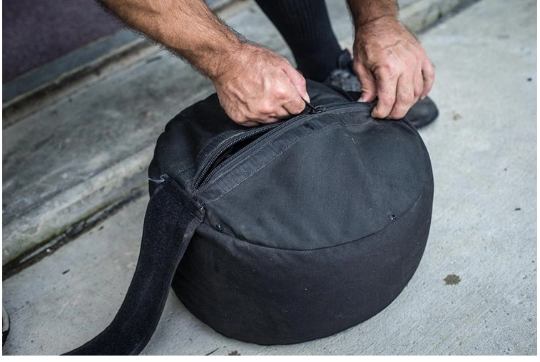 Heavy-duty fitness training weight-bearing sandbag being zipped up.