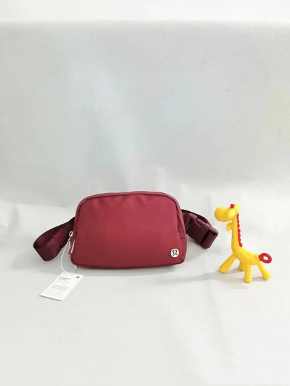 Red crossbody backpack for yoga fitness sports with toy giraffe.