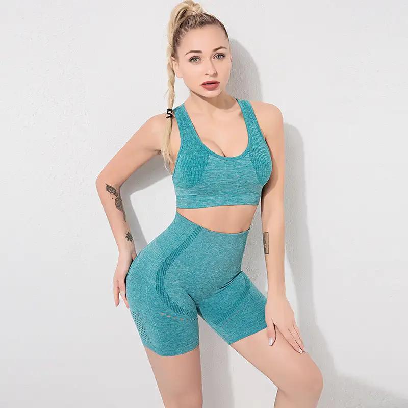 Woman wearing turquoise yoga shorts fitness suit against white background.