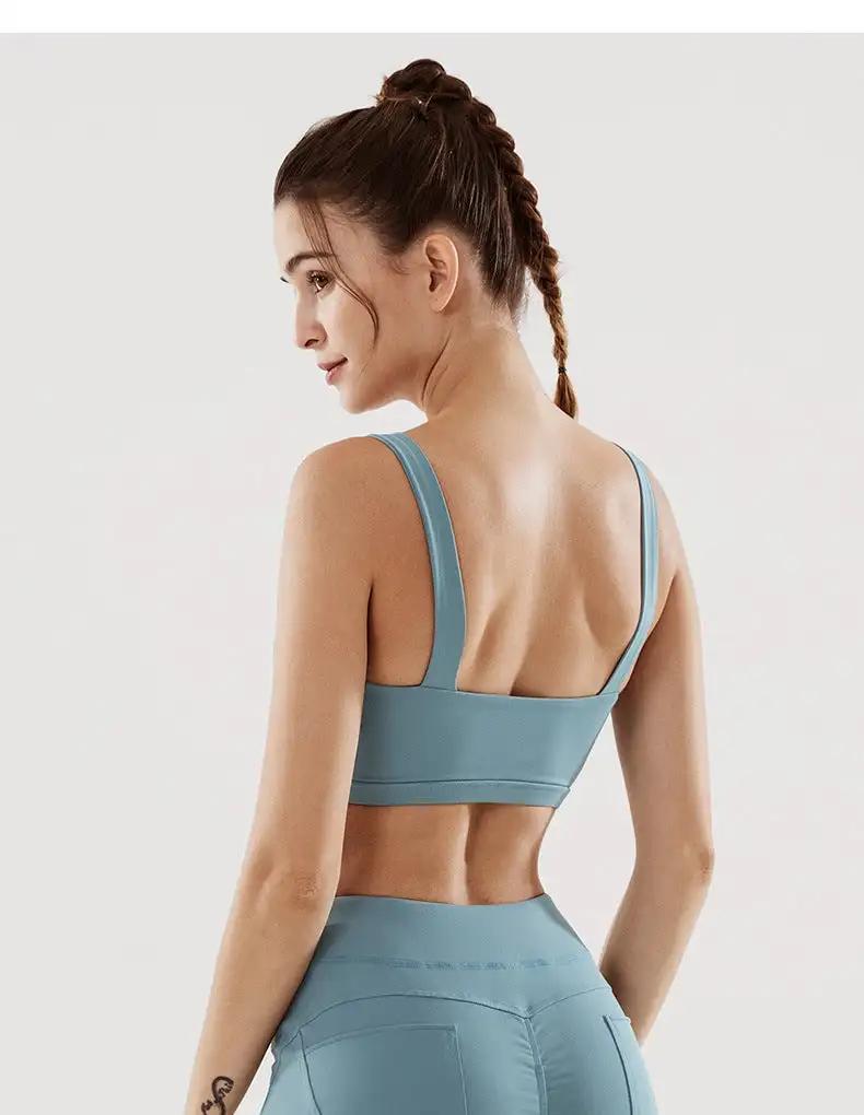 Woman wearing blue fitness yoga underwear set, showcasing back view and braided hairstyle.